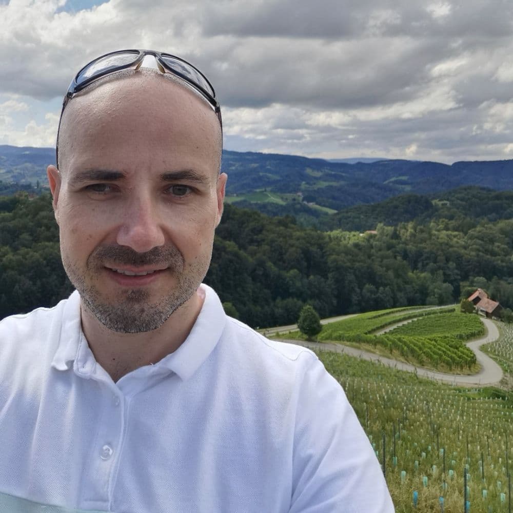 David beli srajci in sončnih očalih se smehlja medtem ko si dela selfi